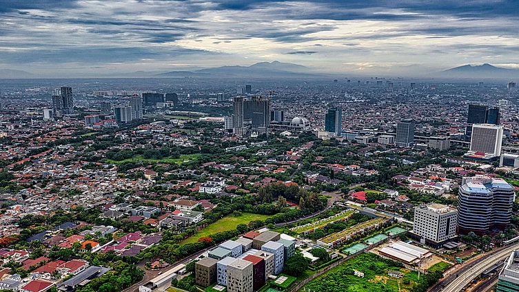 A stunning aerial view of Jakarta's sprawling cityscape with green spaces and high-rise buildings.