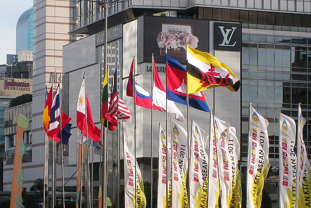 Gambar tersebut memperlihatkan bendera negara-negara anggota ASEAN dengan latar belakang kawasan perkotaan di Jakarta, Indonesia, saat berlangsungnya KTT ASEAN.