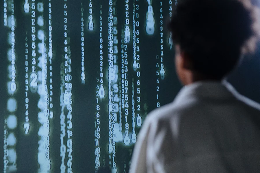 Stylised, vertical streams of numbers flow down the screen, reminiscent of data streams or visual effects from programme code.