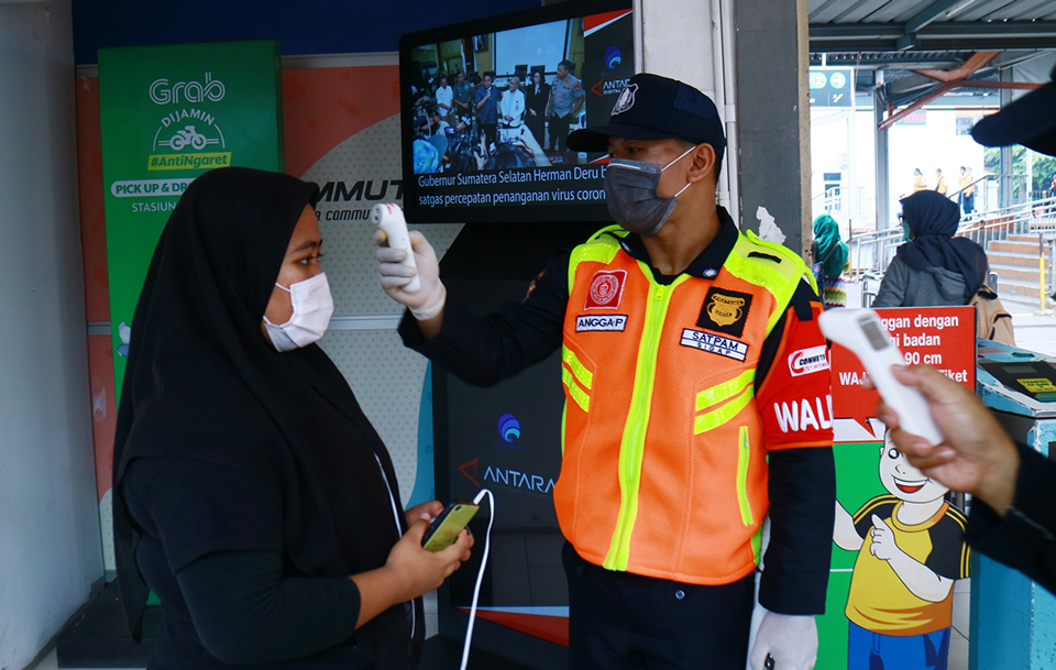 Security officers check the body temperature of passengers at the entrance of Depok Railway Station to prevent the spread of Covid-19. Image: iStock | Joko Harismoyo